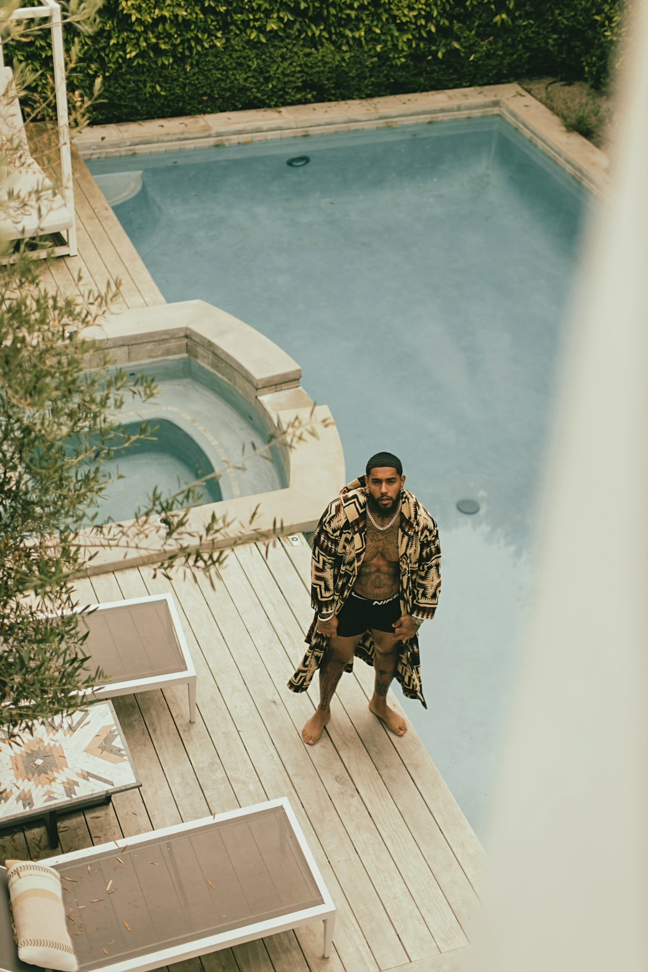 Fredo on a pool deck in a patterned robe